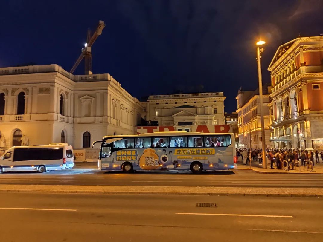 金色大厅前面一辆印着支付宝广告的大巴